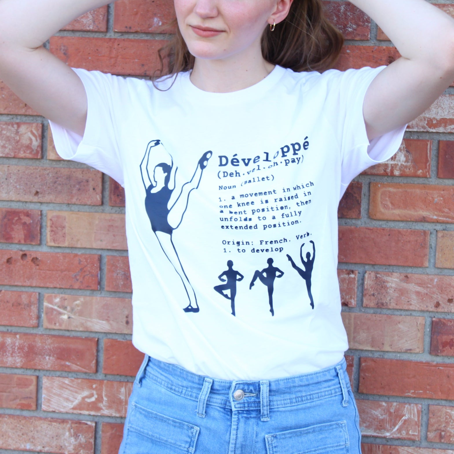 Ballerina performing a developpé a la seconde on T shirt with definition printed in navy blue. Instructions for developpé in ballet